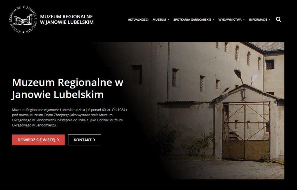 Budynek muzeum z jasnymi ścianami, metalowa brama, kilka okien z kratami, uliczne lampy przy wejściu.