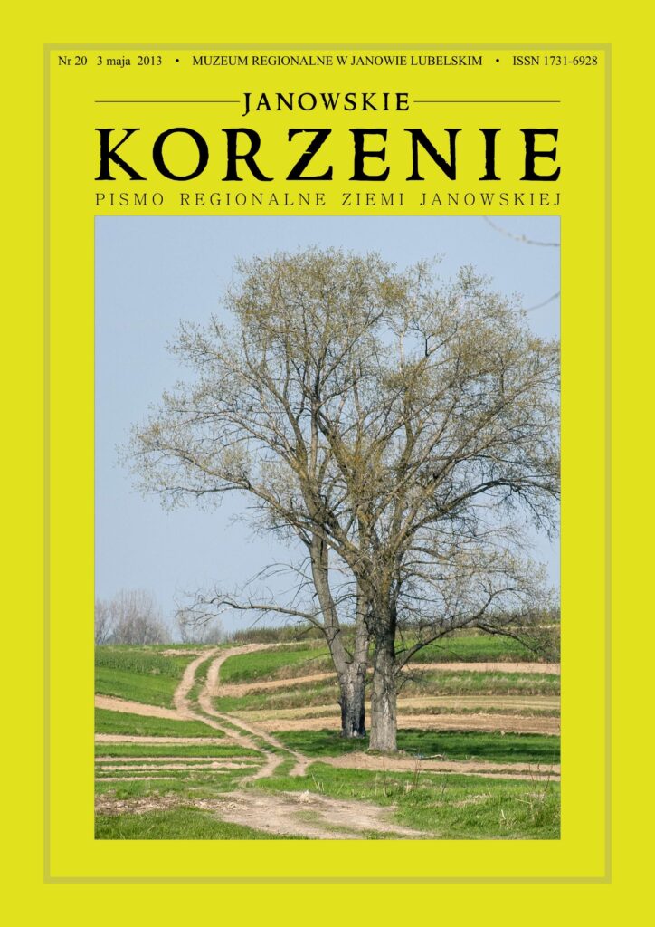 Drzewa z cienkimi gałęziami na tle niebieskiego nieba i zielone pola z ziemnymi ścieżkami.