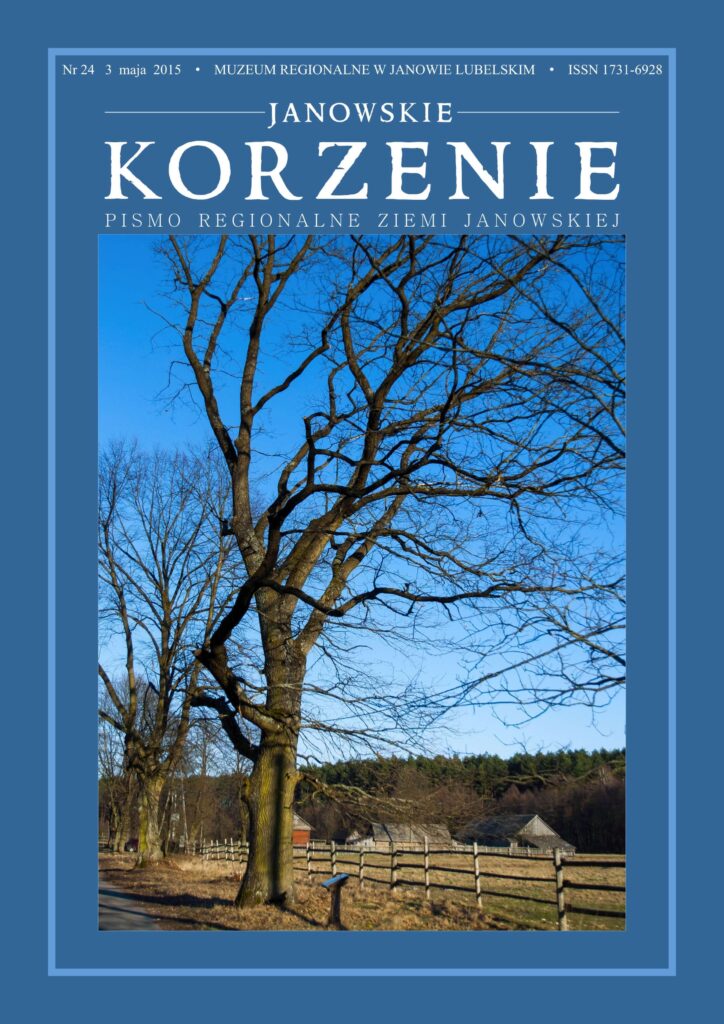 Drzewa bez liści przy drewnianym płocie na tle błękitnego nieba i wiejskich zabudowań.