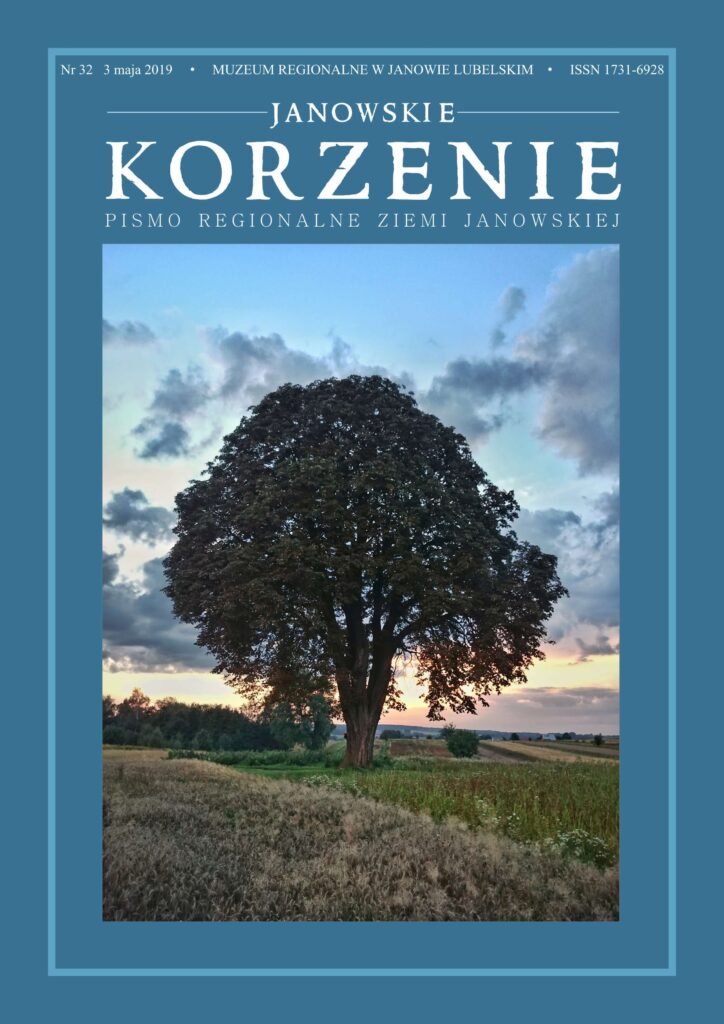 Duże rozłożyste drzewo na polu z zbożem pod niebieskim niebem z chmurami o zachodzie słońca.