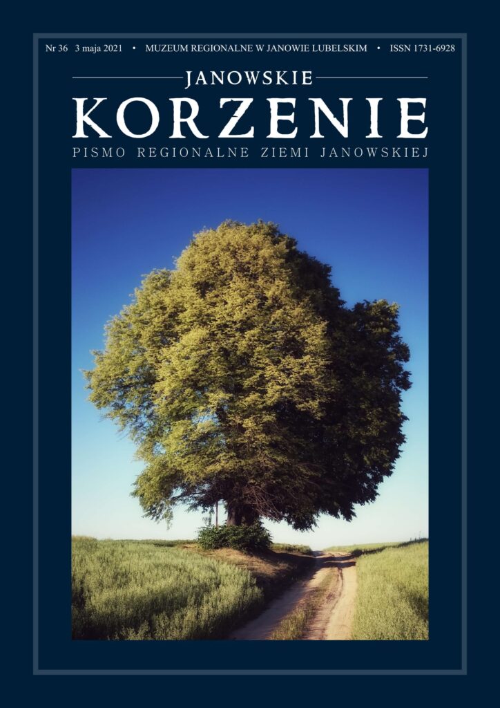 Duże drzewo z gęstą zieloną koroną nad polną drogą, niebieskie niebo w tle, otoczone zielonymi łąkami.