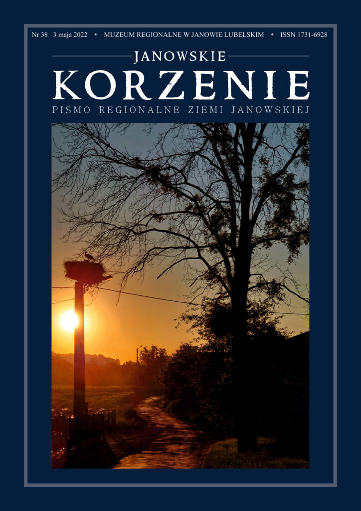 Ciemna sylwetka drzewa i słupa z gniazdem bociana na tle pomarańczowego zachodu słońca nad polną drogą.
