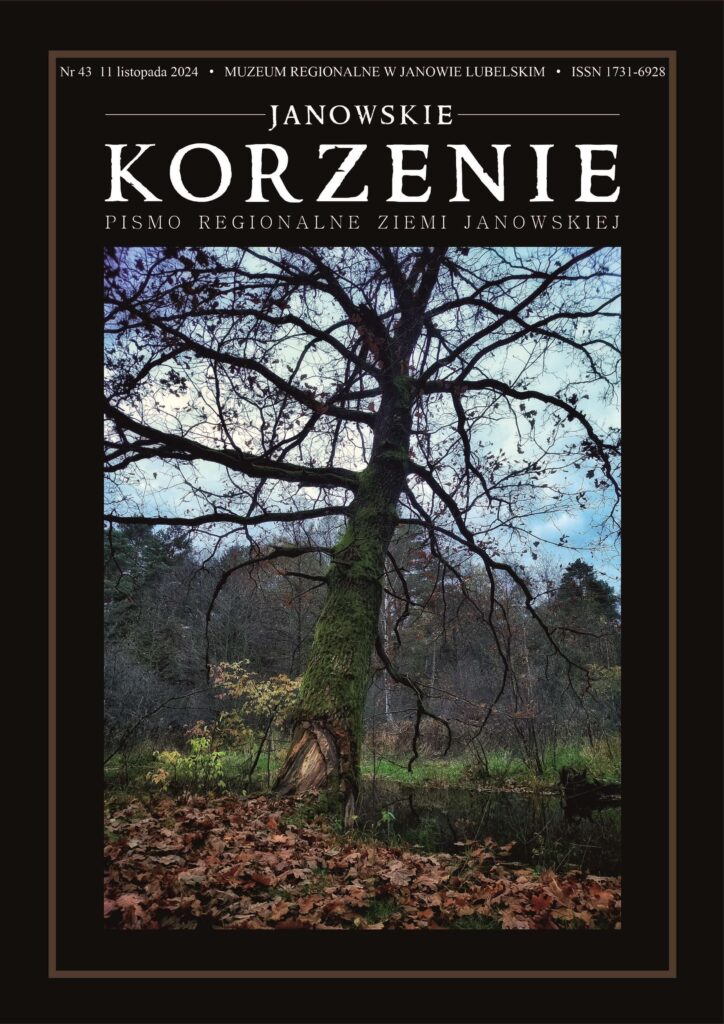Drzewo z omszałym pniem i licznymi gołymi gałęziami na tle nieba, wokół suche liście i zarośla.